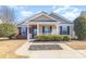 Beige house with brick accents, front porch, and landscaping at 118 Camforth Dr, Mooresville, NC 28117