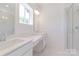 Bright white bathroom with double vanity, glass enclosed shower and large window at 222 Gilead Rd, Huntersville, NC 28078