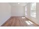 Bright, empty bedroom with wood-look flooring, white walls, and natural light from two windows at 222 Gilead Rd, Huntersville, NC 28078