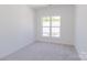 Bright bedroom with neutral walls and carpet, and a large window at 222 Gilead Rd, Huntersville, NC 28078