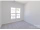 Bright bedroom featuring neutral carpet, crisp white walls, and a window offering views of the neighborhood at 222 Gilead Rd, Huntersville, NC 28078