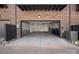 Spacious two-car garage with a brick exterior, high ceilings, and an attached service door at 222 Gilead Rd, Huntersville, NC 28078