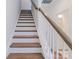 Staircase with white risers and wooden treads, creating a bright and modern look leading upstairs at 222 Gilead Rd, Huntersville, NC 28078