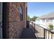 View of a charming balcony with dark wood flooring and a black iron railing on a brick house at 226 Gilead Rd, Huntersville, NC 28078