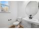 Modern bathroom featuring a pedestal sink and round mirror at 1190 Lost Cove Rd, Indian Land, SC 29707