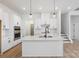 Modern kitchen featuring white cabinets, island, stainless steel appliances, and light wood floors at 1190 Lost Cove Rd, Indian Land, SC 29707