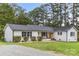 Charming ranch home with white brick exterior, rocking chairs, and landscaped lawn at 2178 Eastview Rd, Rock Hill, SC 29732