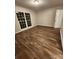 Empty bedroom with wood-look flooring, neutral walls, and a window letting in natural light at 513 Mary Charlotte Dr, Charlotte, NC 28262