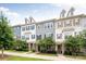 Row of three-story townhouses with gray and beige siding and landscaping at 9714 Ainslie Downs St, Charlotte, NC 28273