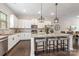 Modern kitchen with white cabinets, granite countertops, and an island with barstools at 9714 Ainslie Downs St, Charlotte, NC 28273