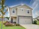 Two-story house with beige siding, stone accents, and a two-car garage at 102 Guardian Gate Dr, Mooresville, NC 28115