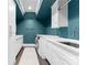 Bright laundry room with teal walls, white cabinets, and a utility sink at 3645 Pelham Ln, Charlotte, NC 28211