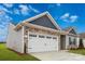 Garage exterior featuring a white garage door, stone accents, and well-maintained landscaping at 180 Wembury Ln, Troutman, NC 28166