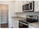 Modern kitchen showcases stainless steel microwave and oven with granite countertops and white cabinetry at 180 Wembury Ln, Troutman, NC 28166