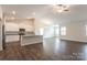 Open concept living area with a view into the kitchen featuring wood floors and lots of natural light at 180 Wembury Ln, Troutman, NC 28166