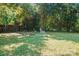 Backyard featuring a fire pit area with chairs, green grass, and plentiful trees at 317 Annafrel St, Rock Hill, SC 29730