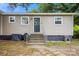 Tan siding home featuring a black front door and a stairway leading up to the entrance at 317 Annafrel St, Rock Hill, SC 29730