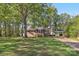 Charming brick single-story home with screened front porch, mature trees and a carport at 1725 Feature Rd, Lancaster, SC 29720