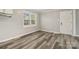 Living room featuring a large window, new flooring and a white entry door at 1725 Feature Rd, Lancaster, SC 29720
