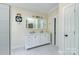 Well-lit bathroom with a dual sink vanity, white cabinetry, and decorative wall mirror at 5300 Green Rea Rd, Charlotte, NC 28226