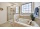 Bathroom featuring a soaking tub next to the glass-enclosed shower with a decorative window at 625 Highland Ridge Pt, Clover, SC 29710