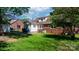 Green backyard showing the home's rear brick and vinyl siding and patio at 112 S 2Nd Ave, Maiden, NC 28650