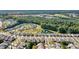 Aerial view of a Primary-planned community with winding roads, lush greenery, and homes surrounding a pond with fountain at 8121 Festival Way, Charlotte, NC 28215