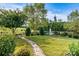 Expansive backyard featuring lush lawn, decorative stone path, mature trees, and serene pond with fountain at 8121 Festival Way, Charlotte, NC 28215