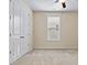 Bedroom with neutral carpet, a ceiling fan, a window, and double doors to the closet at 8121 Festival Way, Charlotte, NC 28215