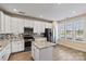 Bright kitchen featuring white cabinets, stainless appliances, granite counters and central island at 8121 Festival Way, Charlotte, NC 28215