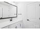 A modern bathroom features a vanity with a black faucet and a framed mirror adding an elegant touch at 5108 Silver Creek Ln, Denver, NC 28037