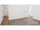 Bright, empty bedroom with hardwood floors, fresh paint, and a closet and door at 5108 Silver Creek Ln, Denver, NC 28037