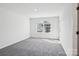 An empty bedroom is brightened with natural light from a window and features neutral walls and soft carpet at 5108 Silver Creek Ln, Denver, NC 28037