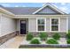 Inviting entryway with stone veneer, green shrubbery, and a black front door at 4280 Stream Dale Cir, Concord, NC 28027