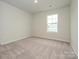 Simple bedroom with natural light and soft carpet, creating a cozy retreat at 10507 Boudreaux St, Huntersville, NC 28078