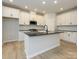 Modern kitchen with white shaker cabinets, dark countertops, and a large island at 10507 Boudreaux St, Huntersville, NC 28078