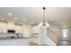 Open concept kitchen with white cabinets and a modern chandelier at 10507 Boudreaux St, Huntersville, NC 28078