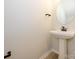 Simple, clean powder room with pedestal sink and round mirror at 10507 Boudreaux St, Huntersville, NC 28078