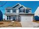 Two-story house with gray siding, stone accents, and a two-car garage at 1809 Augustine St, Monroe, NC 28112