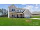 Attractive two-story home with a covered porch, attached garage, and lush green lawn at 126 Brooke Forest Ct, Mooresville, NC 28115