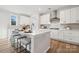 Modern white kitchen with large island, stainless steel appliances, and hardwood floors at 126 Brooke Forest Ct, Mooresville, NC 28115