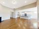 Open-concept living room with hardwood floors and a modern kitchen with white cabinetry and a breakfast bar at 132 Brooke Forest Ct, Mooresville, NC 28115