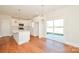 Open kitchen with white cabinets, island, and hardwood floors at 7805 Medlin Rd, Monroe, NC 28112