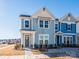 Two-story townhome with light blue siding and a charming front porch at 10505 Boudreaux St, Huntersville, NC 28078