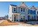 Two-story townhome with light blue siding, stone accents, and a covered porch at 10505 Boudreaux St, Huntersville, NC 28078