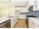 Modern kitchen with white cabinets, stainless steel appliances, and blue tile backsplash at 10505 Boudreaux St, Huntersville, NC 28078