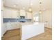 Modern kitchen with white cabinets, white quartz countertops, and a large island at 10505 Boudreaux St, Huntersville, NC 28078