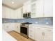 Modern kitchen with white cabinets, stainless steel appliances, and blue tile backsplash at 10505 Boudreaux St, Huntersville, NC 28078