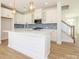 Modern kitchen with white cabinets, white quartz countertops, and a large island at 10505 Boudreaux St, Huntersville, NC 28078