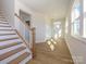 Light-filled entryway with a wooden staircase and hardwood floors at 10505 Boudreaux St, Huntersville, NC 28078